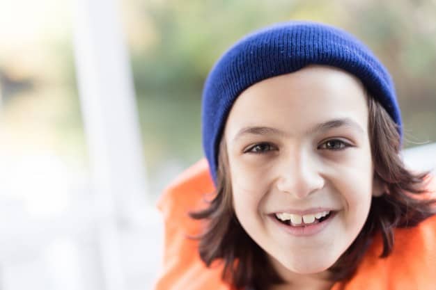 close up cheerful child with knit cap life jacket