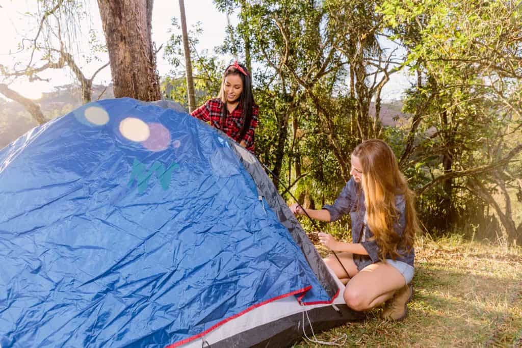 two young women setting tent