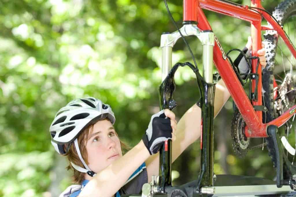 Woman securing her bike on the car rack